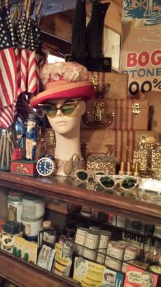 a hat and sunglasses are on display in a shop with american flags hanging from the wall