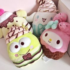 several stuffed animals are in a box with ice cream and donuts on it's sides