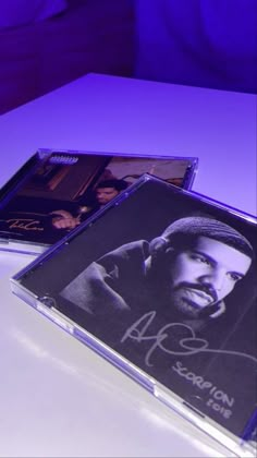 two cds sitting on top of a white table