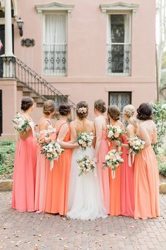 a group of bridesmaids standing in front of a building