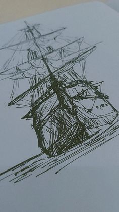 a drawing of a sailboat on paper with pen and ink in the foreground