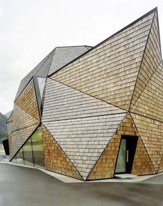 an unusual building with wooden shingles on the roof