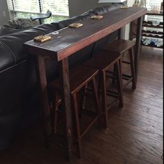 a table with two stools in front of it and a couch next to it