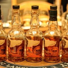 six bottles of liquor sitting on top of a wooden table