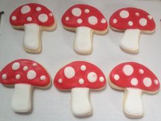 cookies decorated with red and white mushrooms on a baking sheet