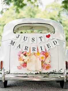 a wedding car decorated with flowers and just married banner