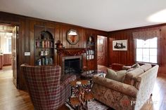 a living room with wood paneling and furniture