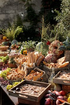 a table filled with lots of different types of foods and vegetables in baskets next to each other