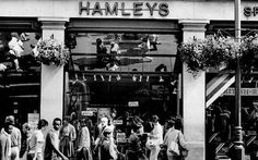 black and white photograph of people walking in front of a store