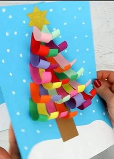 someone is making a christmas tree out of construction paper and colored construction paper with glue