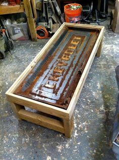 an old sign is sitting on the ground in a garage with tools and other items