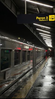 the train is stopped at the station in the rain