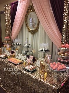 a table topped with lots of cakes and desserts next to a mirror on the wall