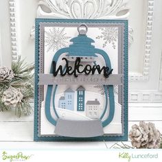 a christmas card with a lantern and snowflakes on the window sill behind it