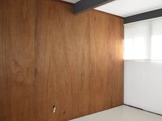 an empty room with wood paneling on the walls