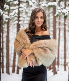 a woman standing in the snow with her arms crossed and wearing a fur coat over her shoulders