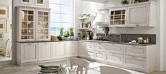 a large kitchen with white cabinets and counter tops