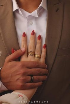 a man and woman holding each other's hands with wedding rings on their fingers