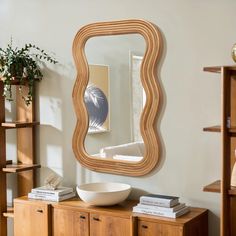 a bowl is sitting on top of a wooden cabinet in front of a large mirror