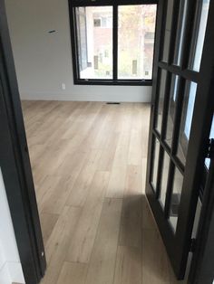 an empty room with wood flooring and large open doors that lead to the outside