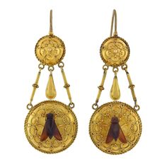 An unusual and exquisite pair of earrings from the Victorian (ca1880s) era! Crafted in blooming 18kt yellow gold, these superb earrings begin with a simple earring wire above a round topper. The surmount is slightly convex and ornately adorned with delicate Etruscan wirework, and encircled by a twisted rope border. A teardrop-shaped link dangles from the center and a larger, complementary gold disc attached by two decorative arms hangs below. Resting in the center of the larger circular link is Fly Earrings, Black Cat Superstition, Ancient Jewels, Rope Border, Poison Ring, Earring Wire, Chandbali Earrings, Gold Legs, Gold Disc