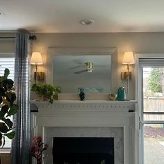 a living room filled with furniture and a fire place next to a window covered in curtains