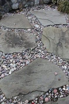 a stone path with rocks and gravel in the middle