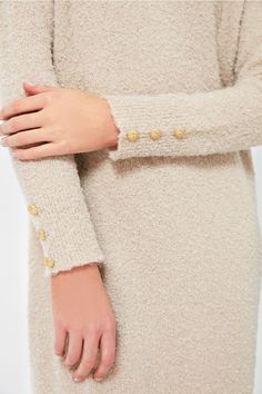 As cozy as a sweater as it is a chic dress, Nelle will take you from clocking hours at the office to dinner followed by a show with a quick switch of accessories. Crafted from a creamy tan boucle knit fabric with gold buttons detailed on the cuffs, this minimalistic maxi is ready to be dressed up or down. With a relaxed fit that is as comfortable as it is flattering, we are wearing this with heels and gold jewelry for a timeless look. Crew neckline Long sleeves Gold buttons on cuffs Relaxed fit Elegant Long Sleeve Neutral Sweater, Elegant Beige Sweater With Buttons, Elegant Fitted Neutral Sweater, Beige Textured Knit Dress For Fall, Elegant Beige Knit Sweater Dress, Cream Long Sleeve Sweater Dress For Work, Beige Knit Sweater Dress For Work, Elegant Cream Sweater With Buttons, Chic Beige Long Sleeve Sweater Dress