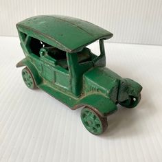 a green toy truck sitting on top of a white table