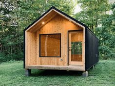 a small cabin in the middle of some grass