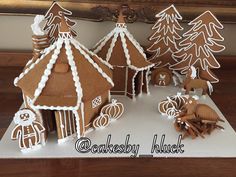 gingerbread houses and trees are displayed on a table