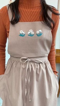 a woman wearing an apron with flowers on it