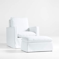 a white chair and footstool sitting next to each other on a white floor