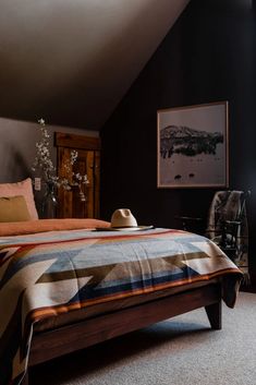 a bed sitting in a bedroom next to a window with a hat on top of it