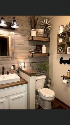 a white toilet sitting next to a sink in a bathroom under two wooden shelvings