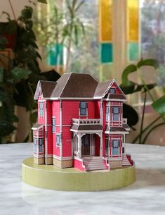 a red doll house sitting on top of a table