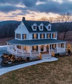 a large white house sitting on top of a lush green field