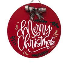 a red merry christmas sign hanging on a wall with a bow around it's neck