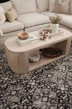 a living room with a couch, coffee table and rug in front of the couch