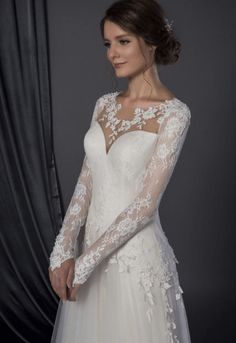 a woman wearing a wedding dress with long sleeves