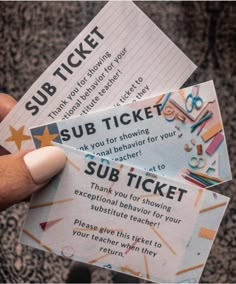 someone holding up two tickets for sub ticket