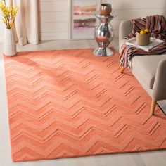 a living room with an orange rug on the floor