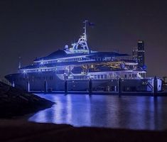 a large cruise ship docked in the water at night