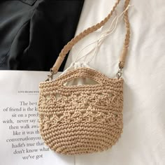 a straw bag sitting on top of an open book