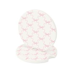 a white and pink toilet seat cover with bows on the lid, sitting against a white background