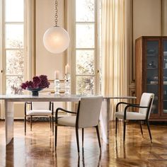 a dining room table with chairs and a vase on it