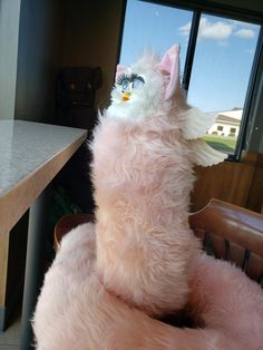 a pink stuffed animal sitting on top of a chair