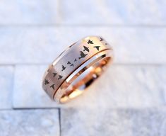 two wedding bands with birds on them are sitting on the ground next to each other