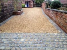 an alley way with brick walls and cobblestone walkway leading to a blue door