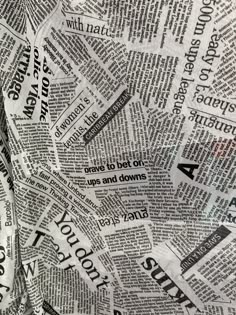 a pile of newspaper paper that has been cut into smaller pieces with words on them